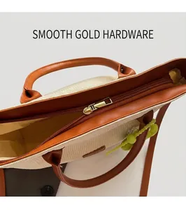 Détail de la fermeture éclair dorée sur le sac cabas tissé beige avec garniture en cuir