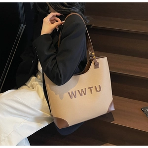Detail of vintage beige tote bag with leather corners and WWTU letter print