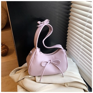Detail of lavender lychee-grain handbag with bow decoration and metal zipper hardware