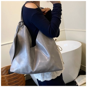 Detail of grey large capacity tote bag featuring soft leather texture and knot decoration