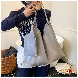 Detail of grey-purple tote bag set featuring a textured faux leather finish and knot handle