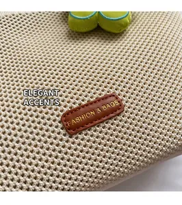 Détail du tissage en maille du sac cabas beige avec un écusson en cuir marron