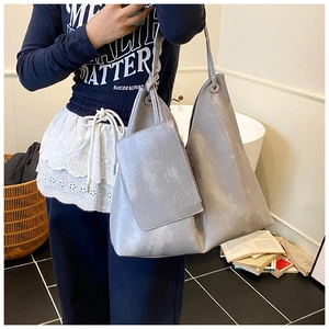 Detail of grey large capacity hobo tote bag and matching pouch with knot strap design