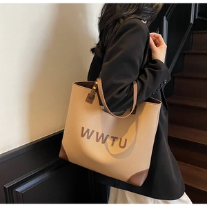 Detail of khaki pebbled leather tote bag with brown straps and WWTU letter print