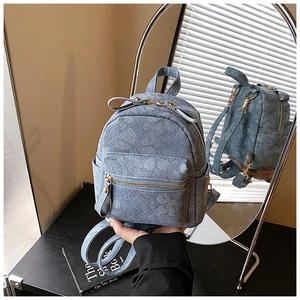 Detail view of light blue mini backpack with floral pattern and golden hardware features