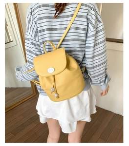 Detail of yellow lychee texture leather mini backpack with drawstring and flap closure