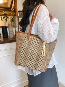Large woven straw beach tote bag with brown leather straps and striped texture detail