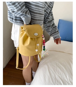 Detail of yellow lychee grain PU leather backpack with colorful beads and bunny logo