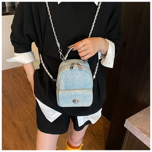 Fashionable light blue denim backpack with silver chain strap and metal twist lock closure