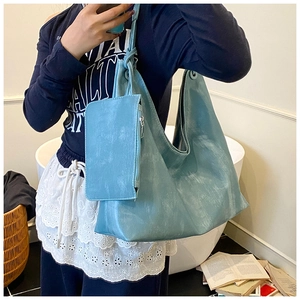 Detailed view of light blue tote bag with matching zippered pouch on shoulder