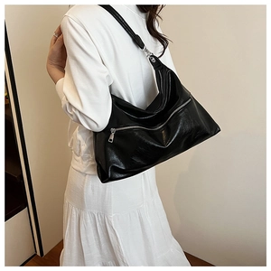 Fashionable black hobo tote bag in glossy finish shown on model for daily commuting