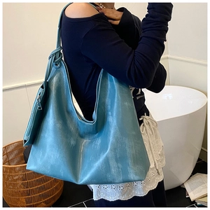 Detail of blue oversized hobo tote bag with vintage texture and matching pouch