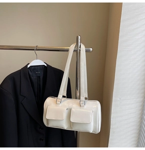 Close-up of white boston bag with double front utility pockets and silver zipper