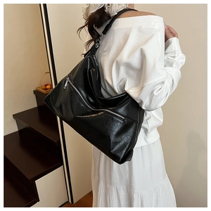 Detail of black Hobo bag showing soft glossy PU leather texture and silver metal zipper