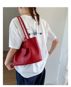 Rote Tote-Bag aus Leder mit Narbenstruktur über der Schulter am Modell präsentiert
