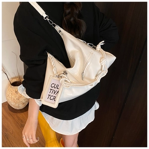 Detail of white large capacity hobo bag with knotted strap and functional side pocket