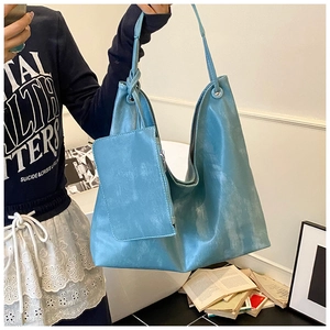 Close-up of light blue textured tote bag with matching inner pouch for daily commuting