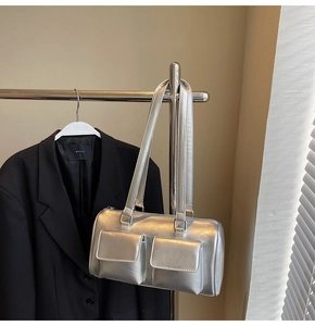 Detailed view of a silver vintage underarm bag with double front pockets on a hanger