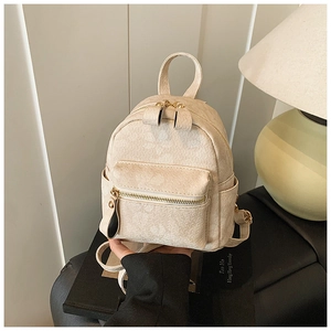 Detail of off-white corduroy mini backpack featuring golden zippers and textured fabric