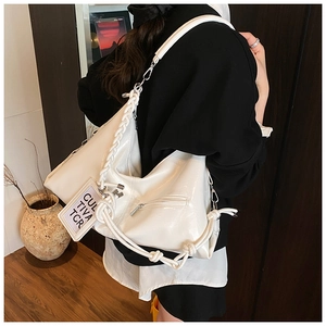 Detail of cream oversized tote bag with braided rope strap and branded square tag
