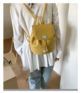 Detail of yellow pebbled leather mini backpack with pearl drawstring and rabbit emblem