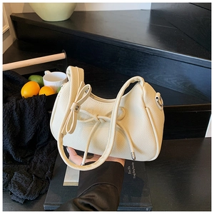 Detailed macro shot of creamy white hobo bag showing premium lychee pattern leather texture
