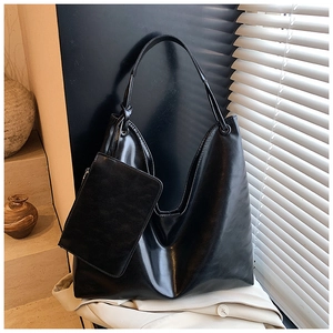 Detail of black leather tote bag set with detachable pouch on minimalist stairs