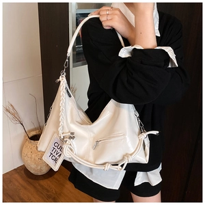 Detail of white glossy tote bag with woven shoulder strap and polished zipper pocket