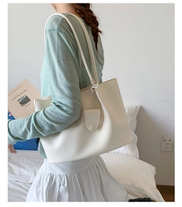 Detailansicht einer weißen Shopper-Tasche aus genarbtem Leder mit passendem Münztäschchen