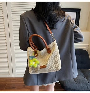 Vue arrière du sac cabas en maille avec poignées en cuir marron et breloque fleur