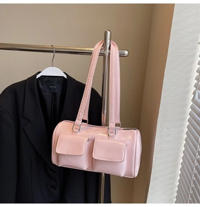 Pink bowling bag detail showing front flap pockets and long straps on a hanger