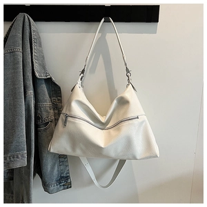 Macro view of white textured leather tote bag with silver front zipper detail