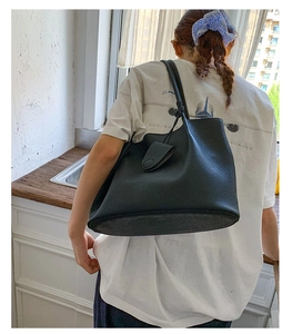 Makro-Detail der schwarzen Tote-Bag aus genarbtem Leder mit geknotetem Riemen