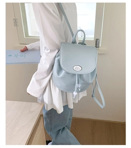 Detail view of light blue leather backpack with lychee texture and rabbit emblem
