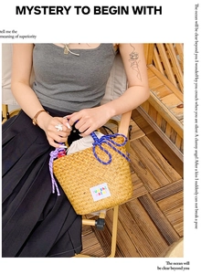 Detail of hand-woven straw bucket bag with blue rope handles and white inner drawstring liner
