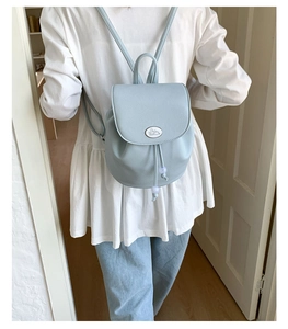 Detail of light blue lychee pattern leather backpack with rabbit logo and drawstring