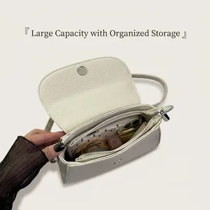 Détails de l'intérieur du sac en cuir litchi blanc montrant la poche et l'espace de rangement