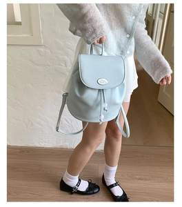 Detail of light blue bucket backpack with Cinnamoroll logo and pebble grain leather