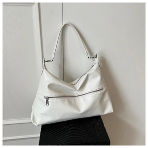 Detail of white tote bag featuring lychee texture faux leather and silver zipper accents