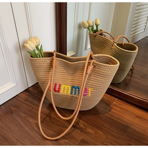 Detail of hand-woven tote bag featuring rainbow Summer embroidery and brown leather handles
