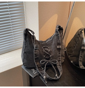 Détail du sac hobo en jean délavé avec design à lacets et boucle métallique robuste