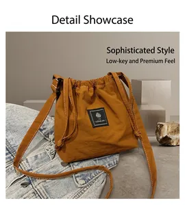 Detail of caramel canvas drawstring bucket bag with adjustable strap and fabric label