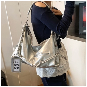 Close-up of silver hobo bag with braided handle and textured metallic finish detail
