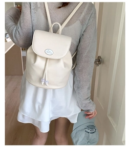 Detail of cream PU leather backpack with cinnamoroll patch and drawstring closure