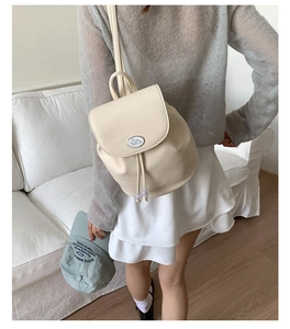 Detail of off-white lychee texture backpack with drawstring and rabbit patch