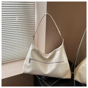 Detailed close-up of cream white faux leather tote bag with soft pleated texture and metal zipper