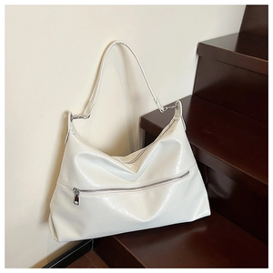 Close-up of a white tote bag with glossy wrinkled leather texture on wooden stairs