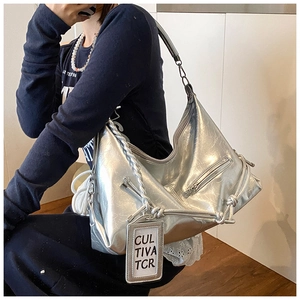 Detail of silver metallic hobo bag featuring braided texture and drawstring knots