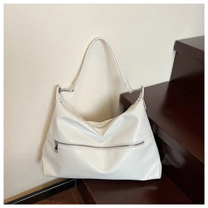 Detail of cream white faux leather hobo bag featuring silver zipper and textured finish