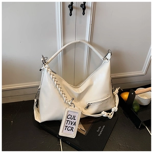 Detail of cream large tote bag featuring a chunky woven strap and side zipper pocket